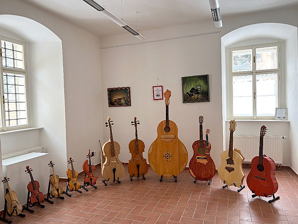 Momentalis Realis. Výstava obrazů a vlastnoručně vyrobených hudebních nástrojů ze dřeva. (zdroj: chvalskyzamek.cz)